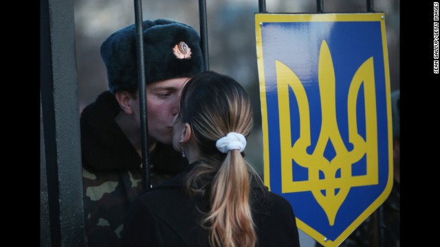 Oleg, a Ukrainian soldier at the Belbek military base in Lubimovka, Ukraine, kisses his girlfriend Svetlana through the gates of the base entrance on March 3. Tensions are high at the base, where Ukrainian soldiers were standing guard inside the building while alleged Russian gunmen were standing guard outside the gates.
