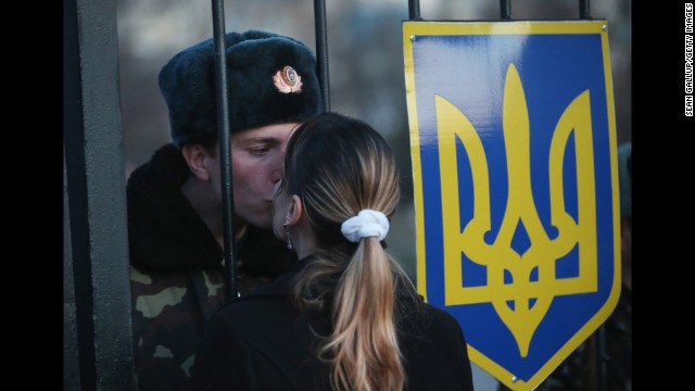 Oleg, a Ukrainian soldier, kisses his girlfriend, Svetlana, through the gates of the Belbek base entrance on March 3. Tensions are high at the base, where Ukrainian soldiers were standing guard inside the building while alleged Russian gunmen were standing guard outside the gates.