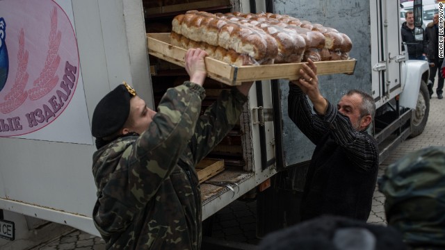 A soldier and a truck driver unload bread outside the Ukranian navy headquarters in Sevastopol on March 2.