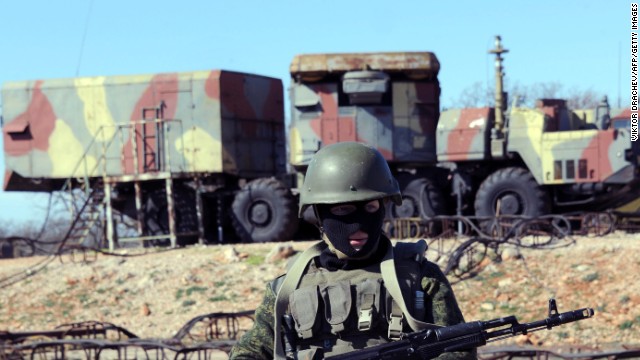 An armed man alleged to be with Russian forces stands guard in front of surface-to-air missiles in Sevastopol on March 5.