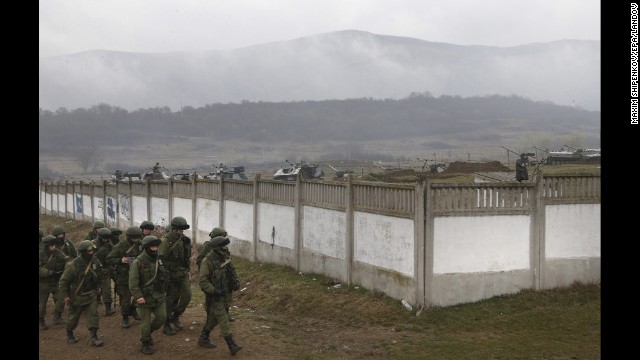 Armed men believed to be Russian military march in a village outside Simferopol on Friday, March 7.