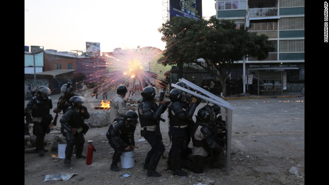 National Guard members take cover as a firecracker launched by protesters explodes nearby in Caracas on Wednesday, March 5.