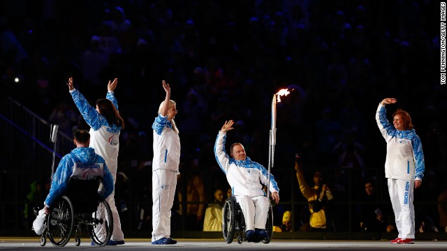 Paralympic torch bearers wave to the crowd.