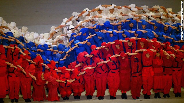 Performers simulate the Russian flag moving in the wind.