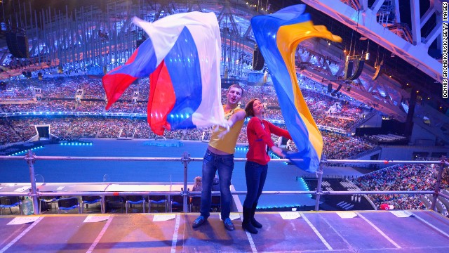 Two spectators pose with Russian and Ukrainian flags during the ceremony.