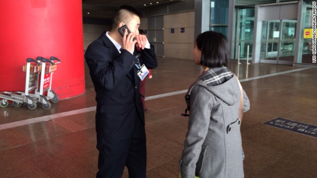 A woman asks a staff member at the Beijing airport for more information on the missing flight.