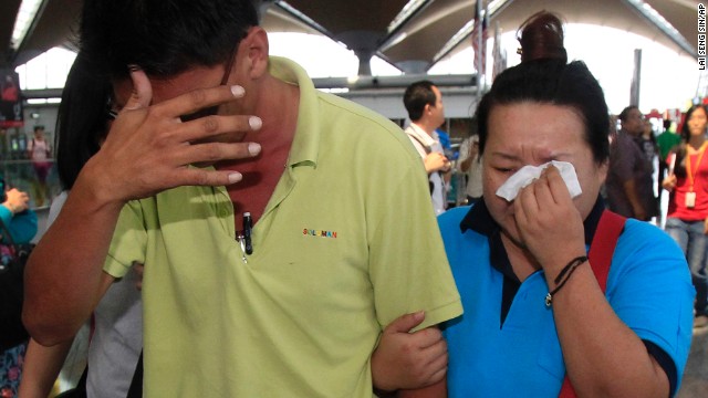 A woman wipes away tears as she walks out of the reception center for family and friends of passengers aboard a missing Malaysia Airlines plane at Kuala Lumpur International Airport on Saturday, March 8. The plane was carrying 239 people from Kuala Lumpur to Beijing when contact was lost.