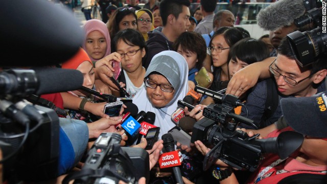 A family member of missing passengers is mobbed by journalists at Kuala Lumpur International Airport on Saturday, March 8.