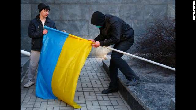 Pro-Russia protesters remove a Ukrainian flag from a flagpole taken from a government building in Donetsk on March 9.