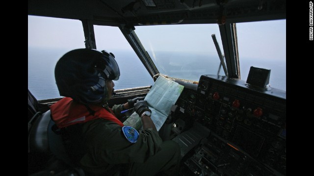 An Indonesian Navy pilot, flying over the waters bordering Indonesia, Malaysia and Thailand near the Strait of Malacca, checks his map during a search operation for the missing Malaysia Airlines jet on Monday, March 10. Contact with the Boeing 777-200 was lost as it flew over the South China Sea early Saturday after leaving Kuala Lumpur for Beijing. It was carrying 227 passengers and 12 crew members.