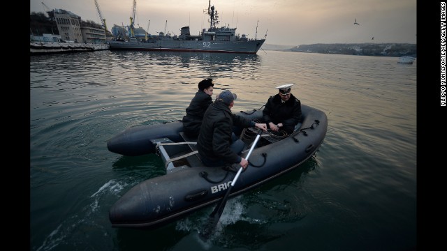 Ukrainian naval officers board a boat in front of the Russian minesweeper Turbinist in Sevastopol's harbor on March 11.