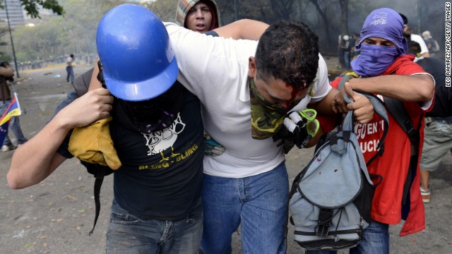 An injured protester is helped away in Caracas on March 12.