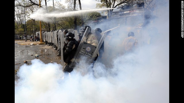 A riot policeman kicks back a tear gas bomb during a protest in Caracas on March 12.