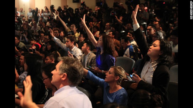 Journalists raise their hands to ask questions during a news conference in Sepang on March 12.