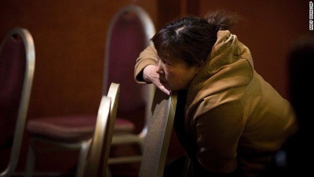 A relative of a missing passenger watches TV at a Beijing hotel as she waits for the latest news March 13.