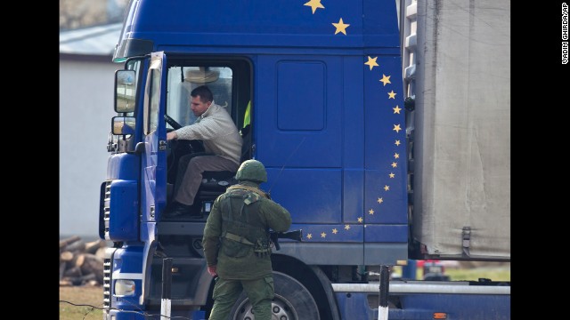 A pro-Russian soldier speaks to a truck driver outside the Ukrainian infantry base in Perevalne on Wednesday, March 12.