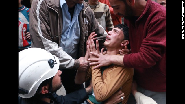 People attempt to comfort a man in Aleppo after a reported airstrike by government forces on Sunday, March 9. 