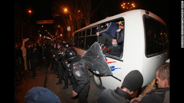 A line of policemen stand in front of a bus of pro-Ukrainian activists as pro-Russian supporters confront them during a rally in Donetsk on Thursday, March 13.