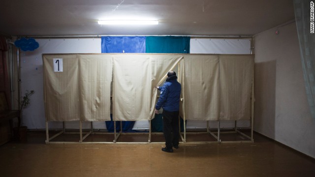 A member of a pro-Russian self-defense unit checks a polling station near Simferopol on March 13.