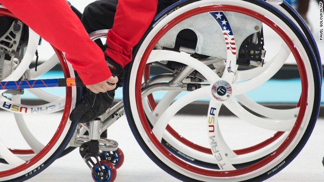 Joseph Jimmy, right, steadies the chair of Lino Meghan of the United States during a curling match against South Korea on March 8.