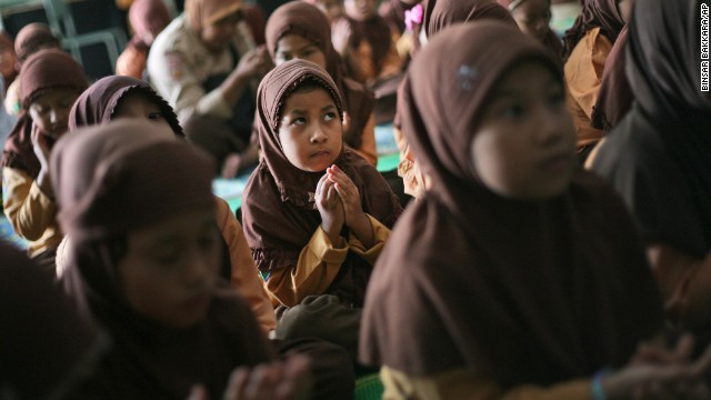 Elementary school students pray for the missing passengers during class in Medan, Indonesia, on March 15.