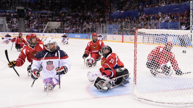 Joshua Sweeney of the United States scores the game-winning goal past Vladimir Kamantcev of Russia during the ice sledge hockey gold medal game between the United States and Russia on March 15.