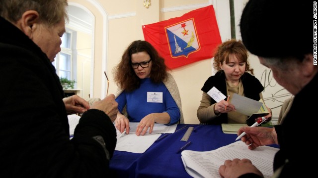 People sign up to receive their ballots from electoral staff at a polling station in Sevastopol.