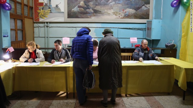 Voters talk to election officials inside a polling station in Simferopol.