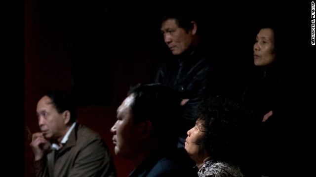 Relatives of missing passengers watch a news program about the missing plane as they await information at a hotel ballroom in Beijing on March 17.