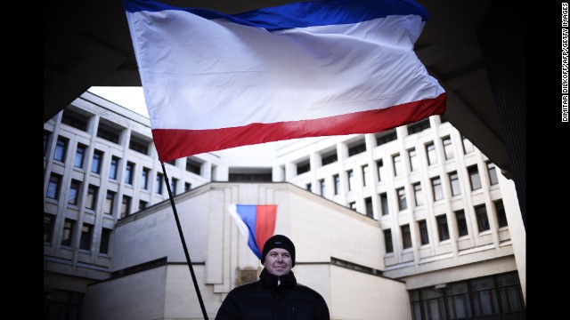 A man holds a Crimean flag as he stands in front of the Crimean parliament building in Simferopol on March 17.