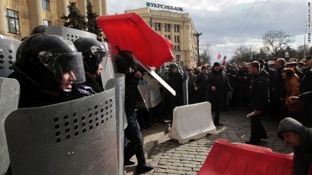 A Ukrainian police officer tries to shield himself from a road block thrown by pro-Russia supporters in Kharkiv, Ukraine, on March 16.