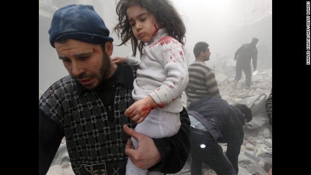 A man carries a child who was found in the rubble of an Aleppo building after it was reportedly bombed by government forces on Monday, March 18.