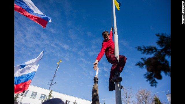 A member of pro-Russian forces takes down a Ukrainian flag at the Ukrainian navy headquarters in Sevastopol on March 19. 