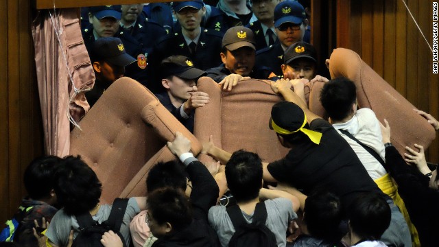 Police officers try to enter the Legislature that is blocked and occupied by activists.