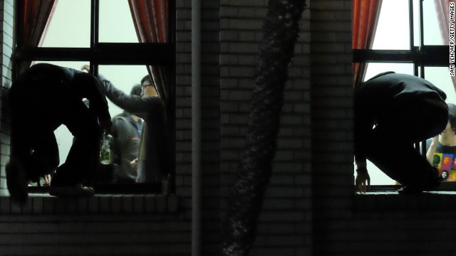 Protesters climb through the windows of the Legislature.