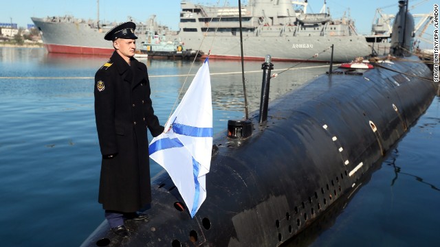 A Russian sailor holds the Russian Navy's St. Andrew's flag while standing on the bow of the surrendered Ukrainian submarine Zaporozhye on March 22 in Sevastopol.