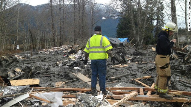 Emergency workers arrive at the scene of the landslide.