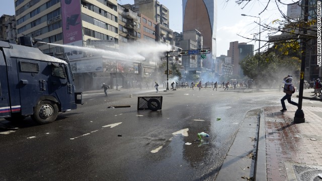 Law enforcement personnel use water cannons to disperse demonstrators on March 22. 