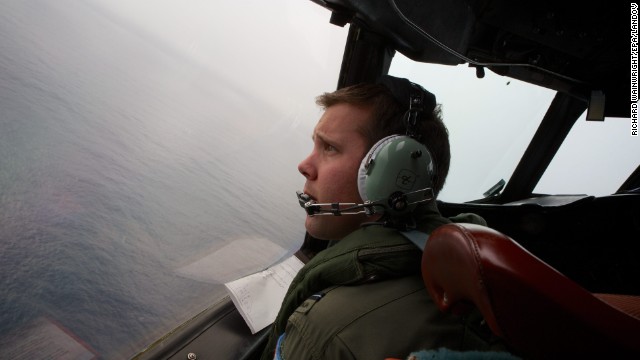 A member of the Royal Australian Air Force looks out an aircraft during a search for the missing jet March 24.