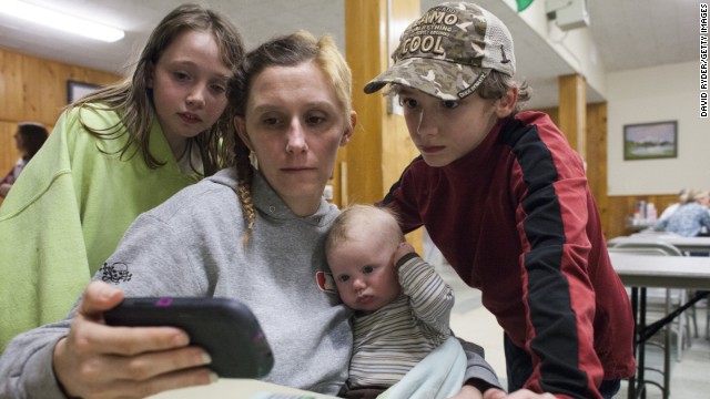 The Langston family watches an online news clip about the landslide on Sunday, March 23, while they stay at a temporary Red Cross shelter in Darrington. The family's home was flooded after the landslide blocked the Stillaguamish River.