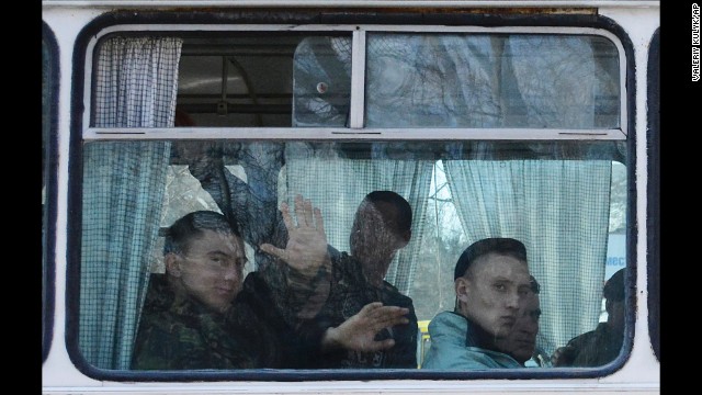 Ukrainian marines wave as they leave a base in Feodosia, Crimea, on Tuesday, March 25. After Russian troops seized most of Ukraine's bases in Crimea, interim Ukrainian President Oleksandr Turchynov ordered the withdrawal of armed forces from the peninsula, citing Russian threats to the lives of military staff and their families.