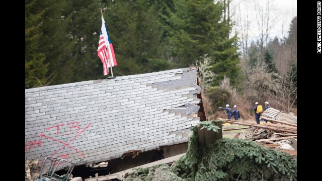 The roof of a house sits among debris as emergency personnel continue to look for survivors on March 25.