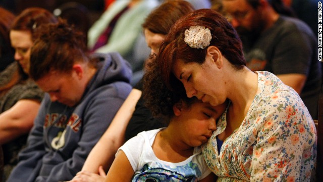 Natalie Reed, right, and her 5-year-old daughter, Deja, attend a prayer service at Arlington United Church on March 24 for those affected by the landslide.