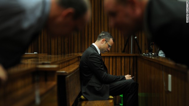Pistorius sits inside the courtroom as members of his defense team talk in the foreground Friday, March 28.