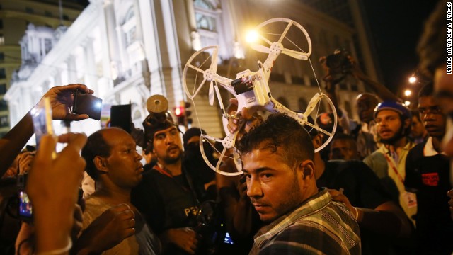 Protesters question a man who was operating a quadcopter drone with camera during February's protests in Rio. 