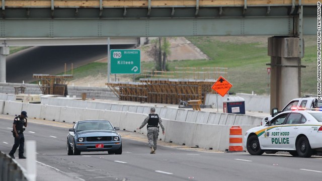 A military police officer stops a car.