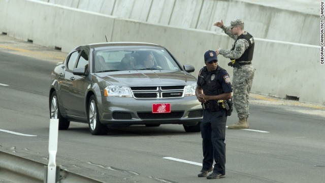 A Bell County Sheriff's Department official stands near a vehicle as cars are checked at the Bernie Beck Gate.