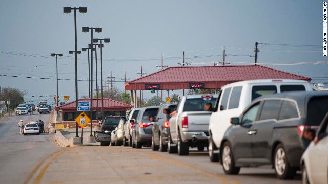 Vehicles wait at a closed entrance to Fort Hood.