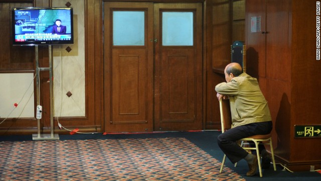 A relative of a Flight 370 passenger watches television in a Beijing hotel as he awaits new information about the missing plane on Thursday, April 3.