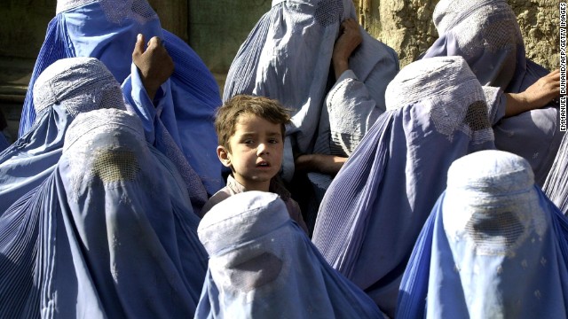  A young boy stands among a group of veiled women waiting to receive food aid during a U.N. World Food Program distribution in Kabul in November 2001. "I myself remember the mujahideen's takeover of Kabul on 27 April 1992," says Mosadiq. "On 26 April I wore a miniskirt and a sleeveless shirt, but the day after I was terrified to walk outside without being fully covered." 